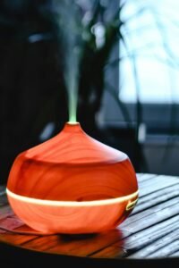 An aromatic wooden diffuser releasing smoke, creating a calm indoor atmosphere near a window.